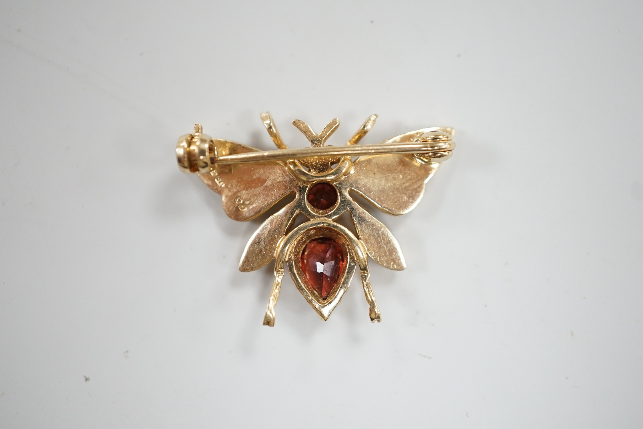 A modern 9ct gold, garnet and split pearl set bug brooch, width 26mm, gross weight 3.8 grams.